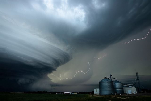 A supercell storm towers over a farm grain elevator in Nebraska ...